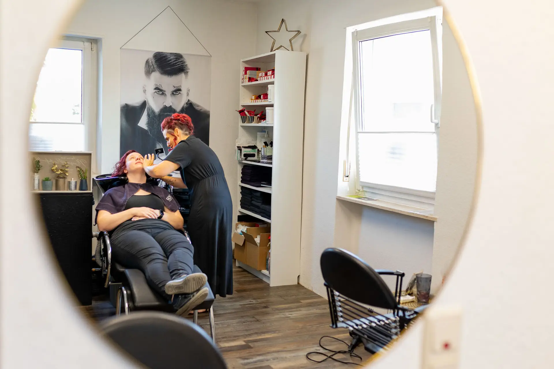 Hochzeitsfotograf fotografiert Braut beim Getting Ready im Friseursalon durch runden Spiegel