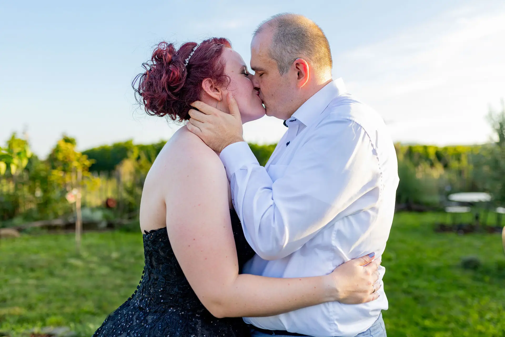 Brautpaar küsst sich innig im Garten von Kellers Keller in der Abendsonne