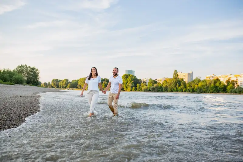 Paar läuft am Kiesstrand der Parkinsel Ludwigshafen durch das Wasser
