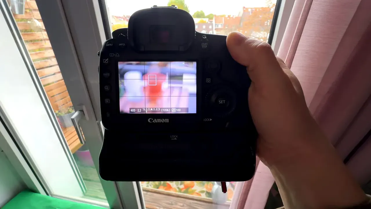 Rückseite einer Canon-Kamera im Live‑View mit Fokusrahmen und Gitter