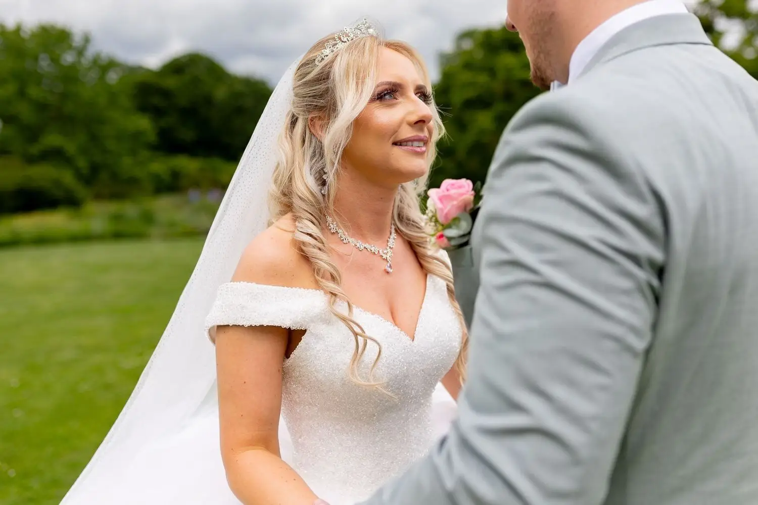 Braut Sandra blickt den Bräutigam verliebt an auf der Wiese des Hermannshofs
