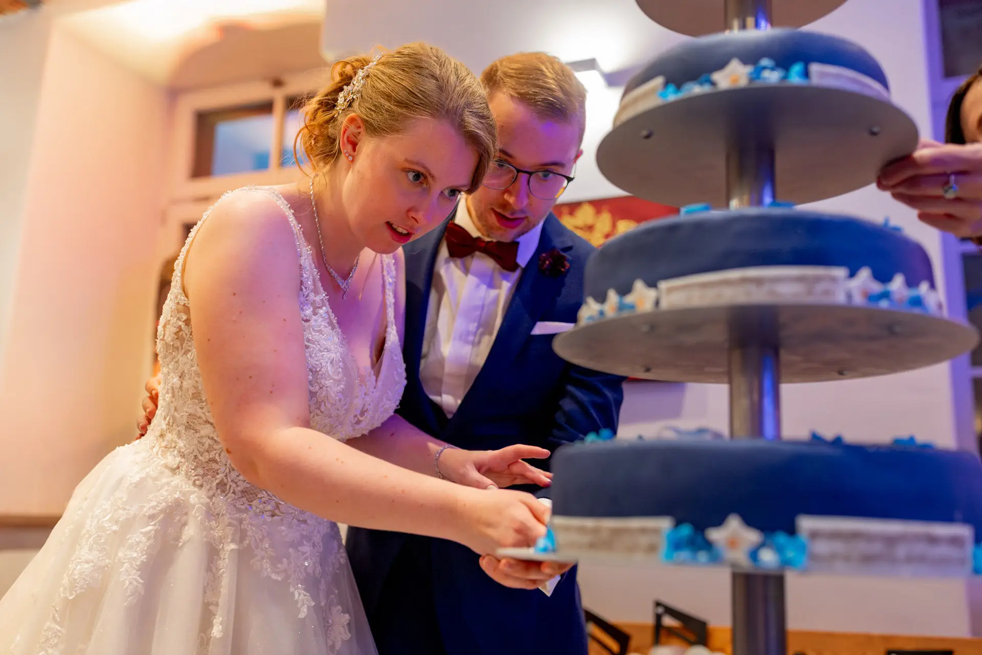 Sandra und Dominic schneiden ihre blaue Hochzeitstorte an in der Ulner Kapelle Weinheim