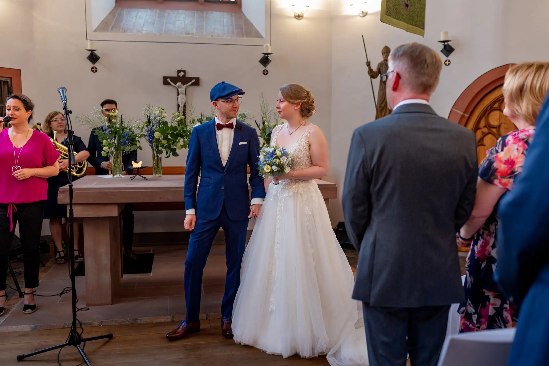 Sandra und Dominic stehen am Altar, Gäste und Sängerin im Hintergrund in der Ulner Kapelle Weinheim