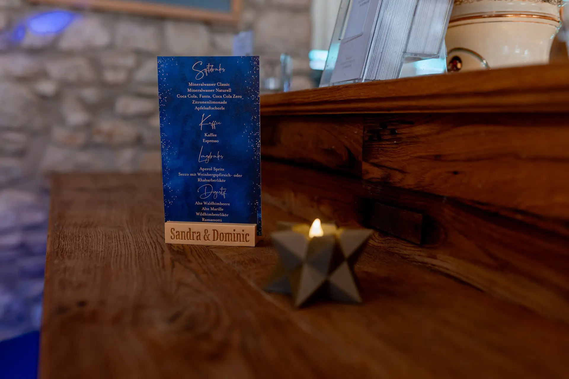 Getränkekarte von Sandra und Dominic mit Sternkerze auf einem Holztresen in der Ulner Kapelle Weinheim
