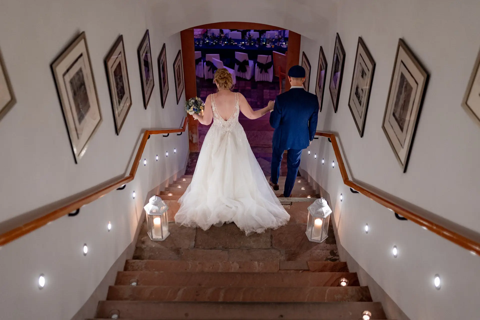 Sandra und Dominic gehen die mit Laternen geschmückte Treppe hinunter in der Ulner Kapelle Weinheim