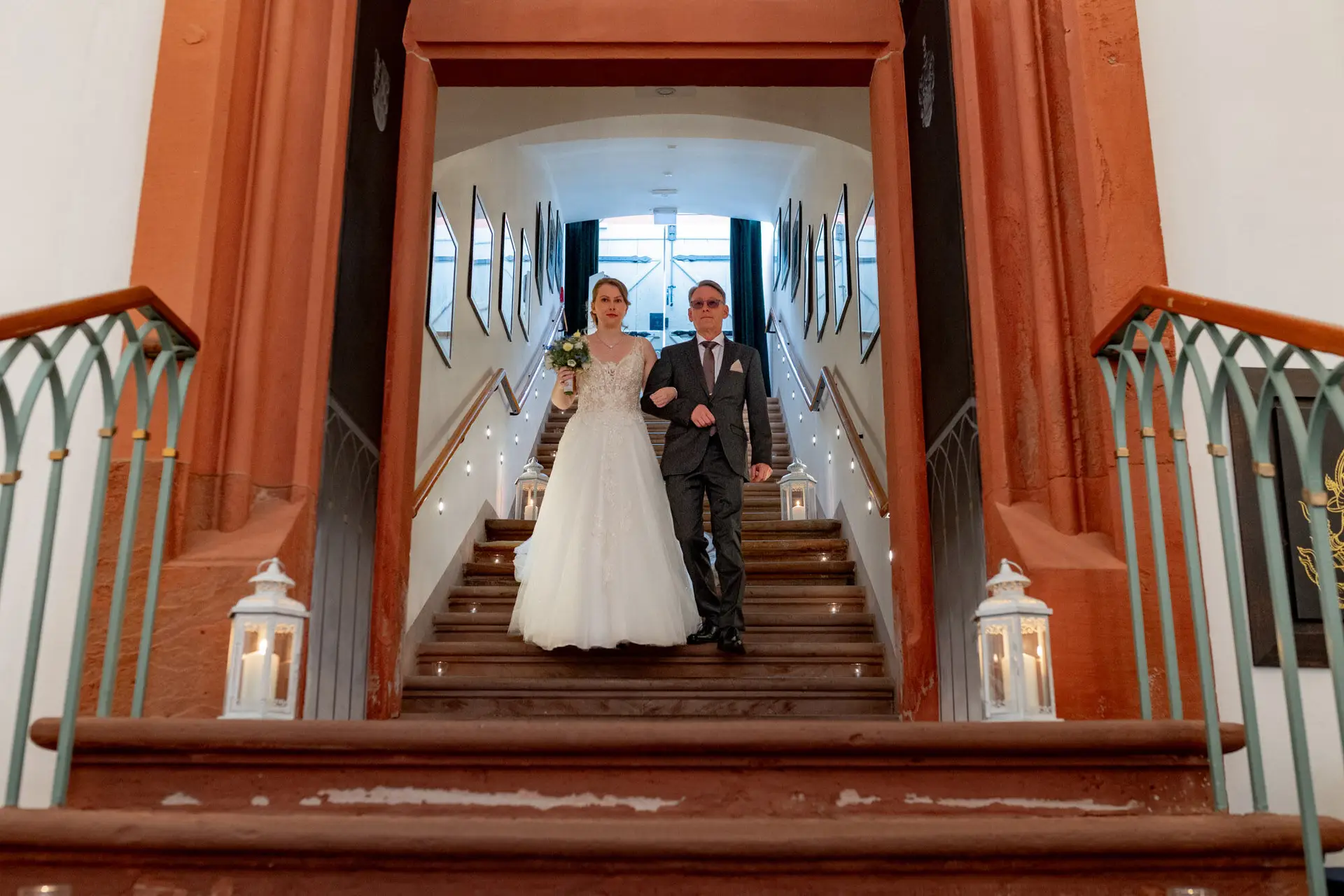 Sandra und Dominic steigen die Treppe zur Ulner Kapelle Weinheim hinunter, links und rechts Laternen