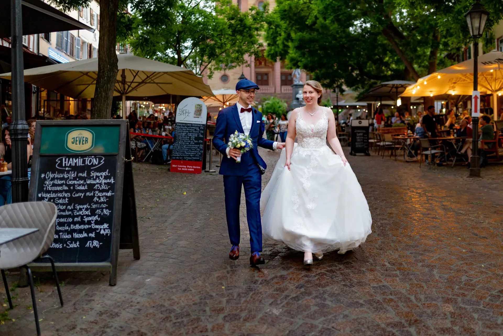 Sandra und Dominic spazieren über einen Platz mit Restaurants in der Weinheimer Altstadt