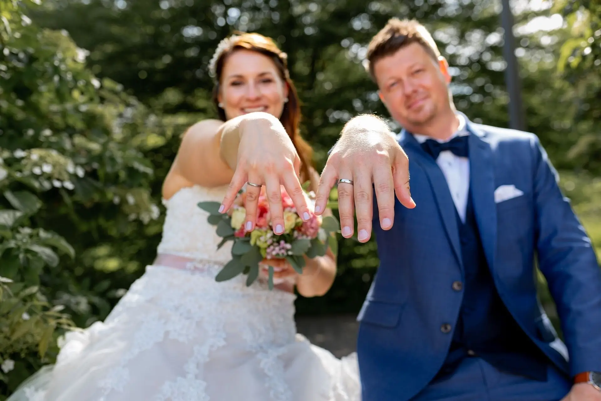 Brautpaar zeigt strahlend ihre Eheringe im Kurpark Bad Dürkheim