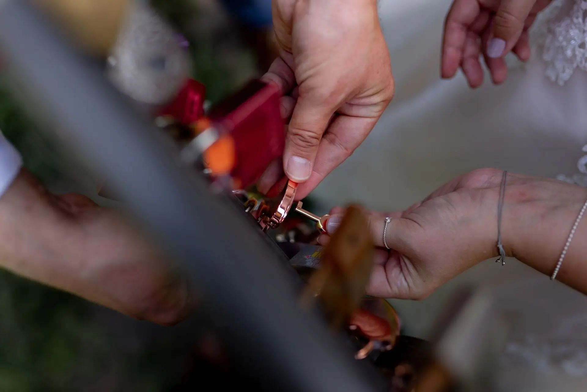 Hände befestigen ein Liebesschloss am Geländer im Kurpark Bad Dürkheim