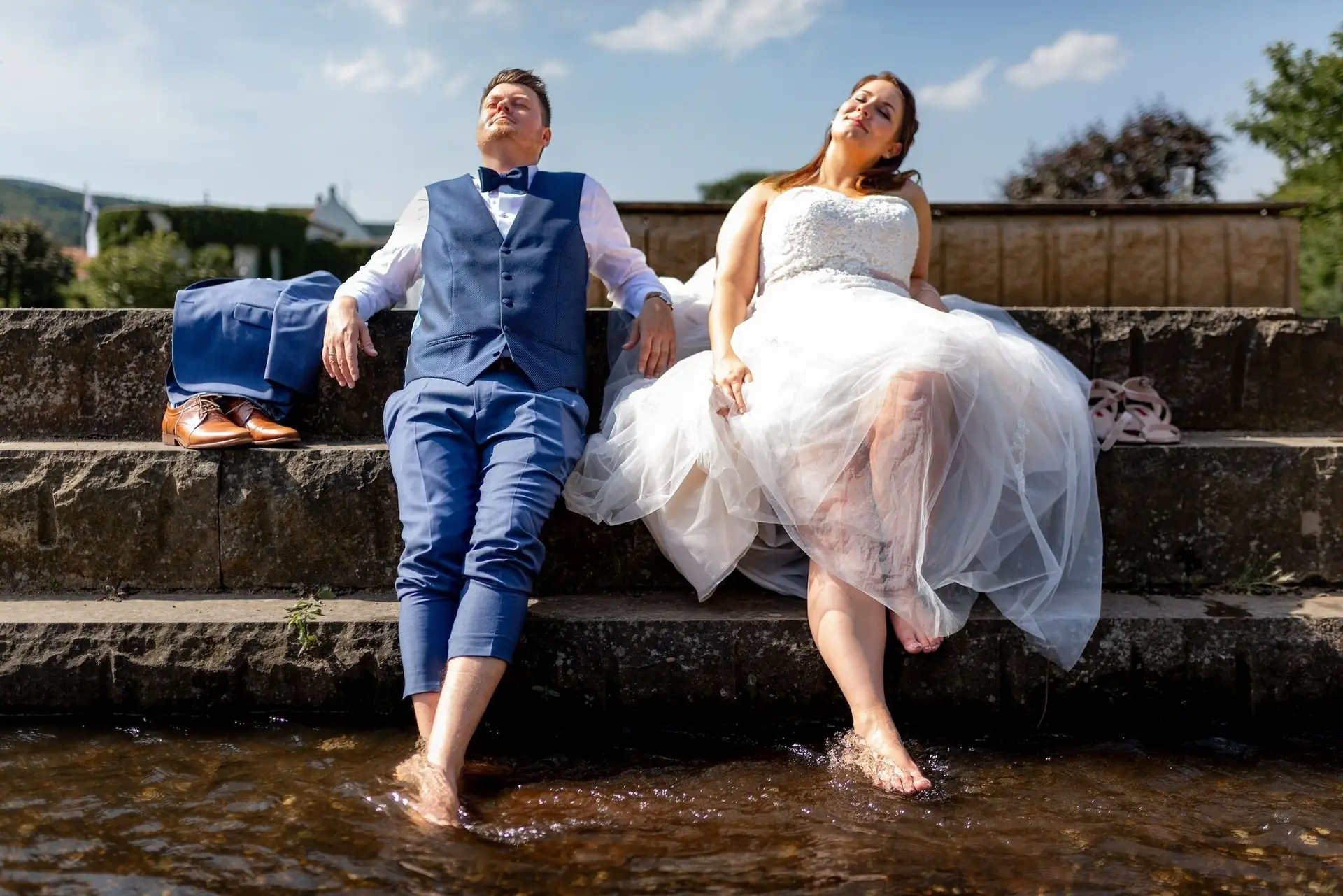 Brautpaar watet lachend gemeinsam durch den Bach im Kurpark Bad Dürkheim