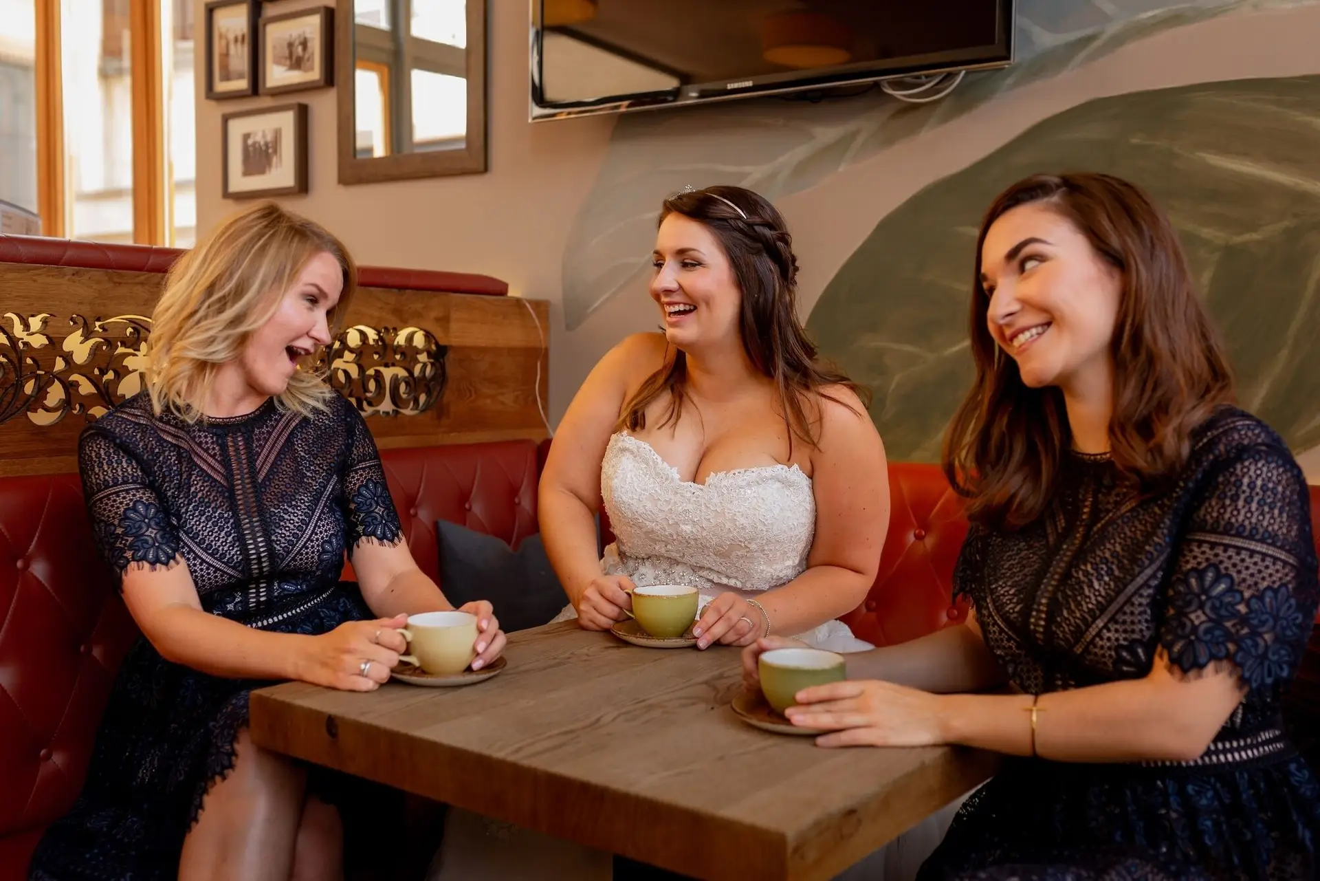 Braut und Trauzeugen lachen beim gemeinsamen Lesen im Café Elisabeth Mutterstadt