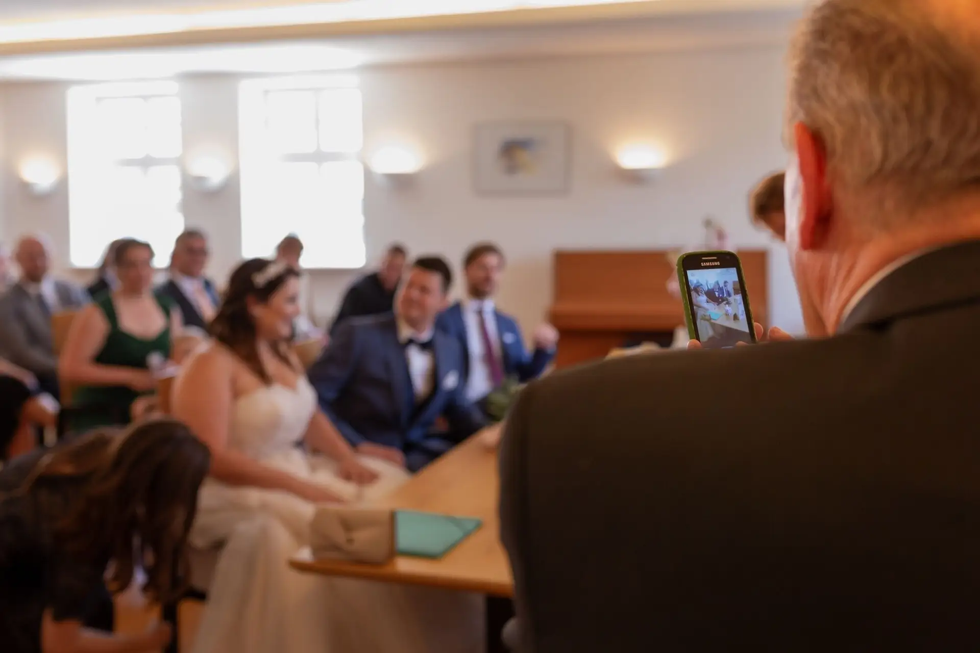 Gast fotografiert Braut und Bräutigam bei der standesamtlichen Trauung im Rathaus Mutterstadt