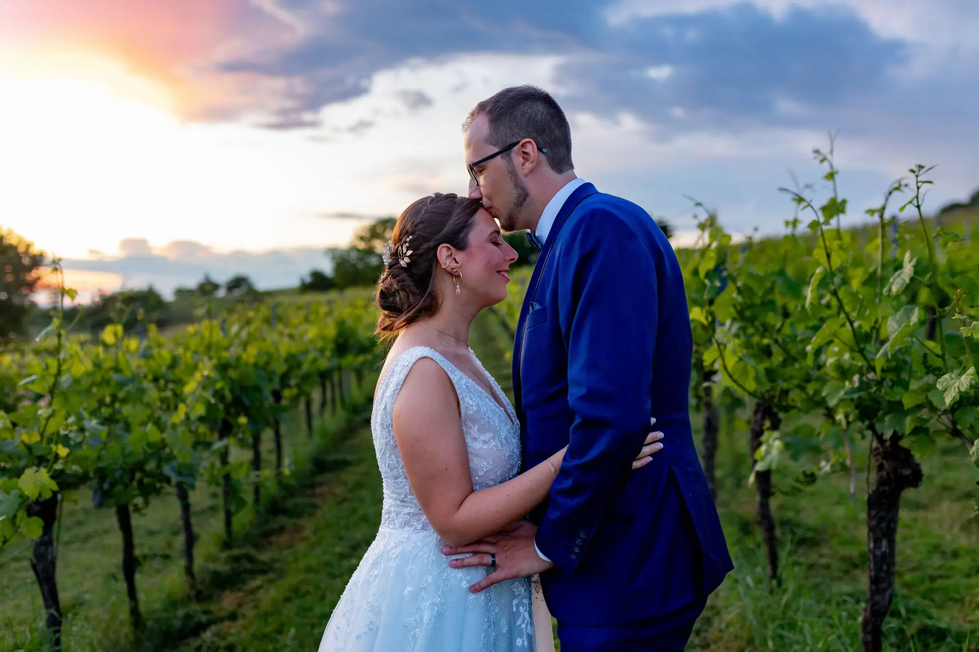 Brautpaar küsst sich innig im Weinberg des Grenzhofs Heidelberg bei dramatischem Abendhimmel
