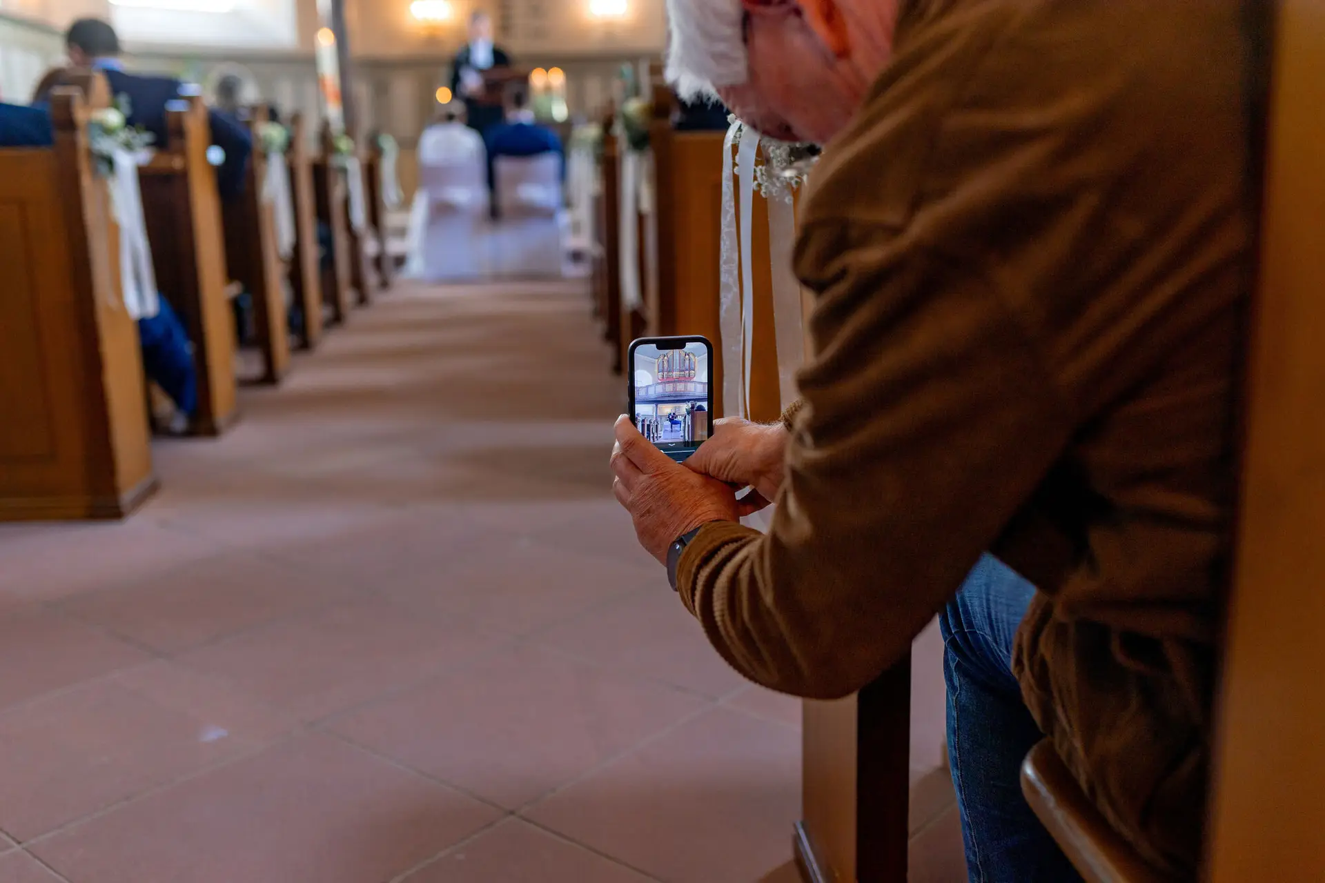 Gast fotografiert den Hochzeitsaltar auf seinem Smartphone in der festlich dekorierten Kirche Mutterstadt