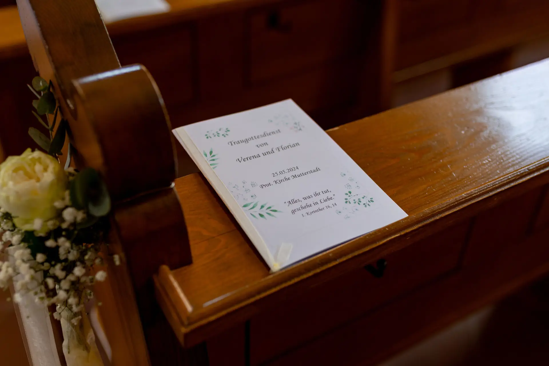 Kirchenheft zum Traugottesdienst auf der Holzbank mit Blumenschmuck in der Kirche Mutterstadt