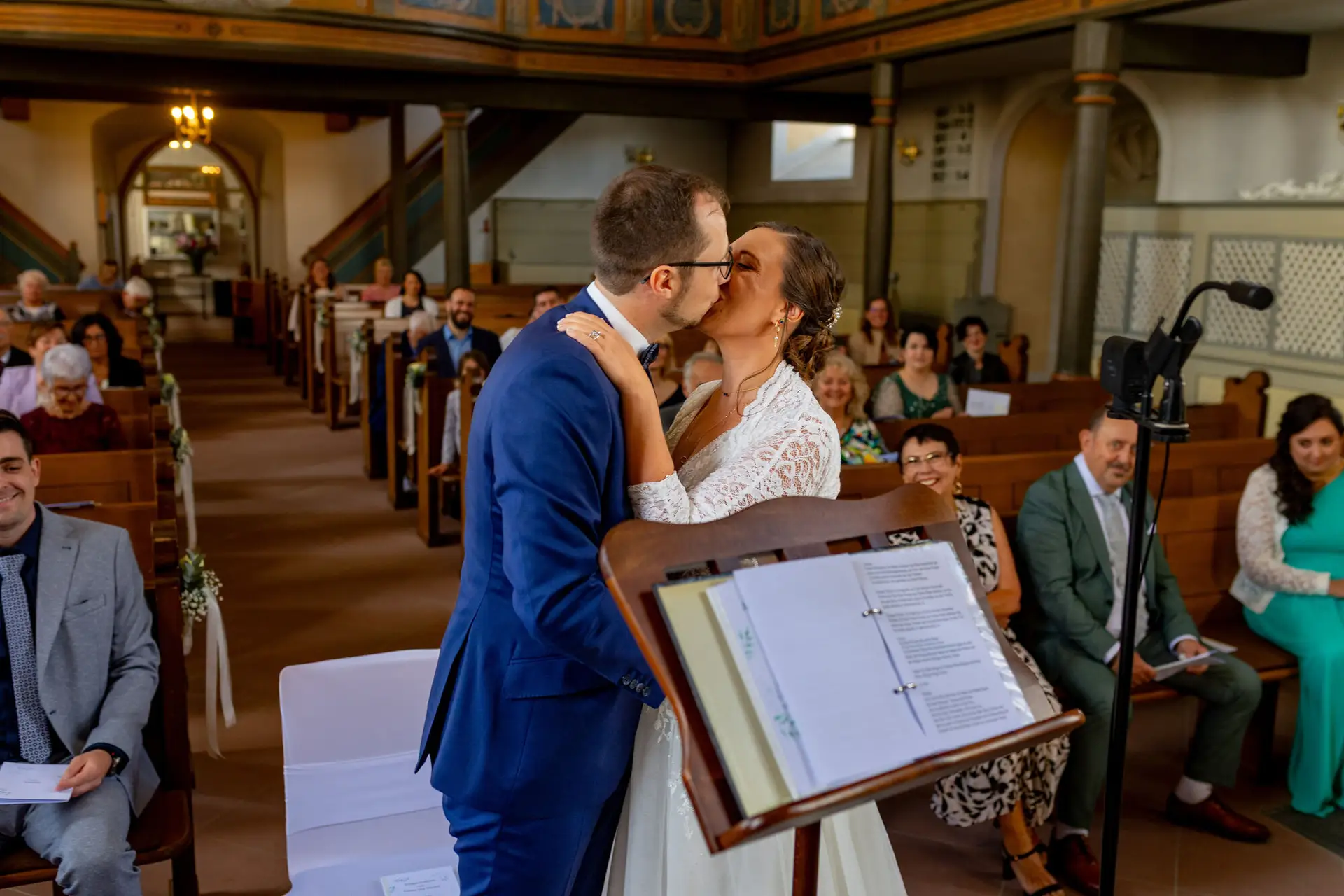 Braut und Bräutigam küssen sich am Altar in der voll besetzten Kirche Mutterstadt